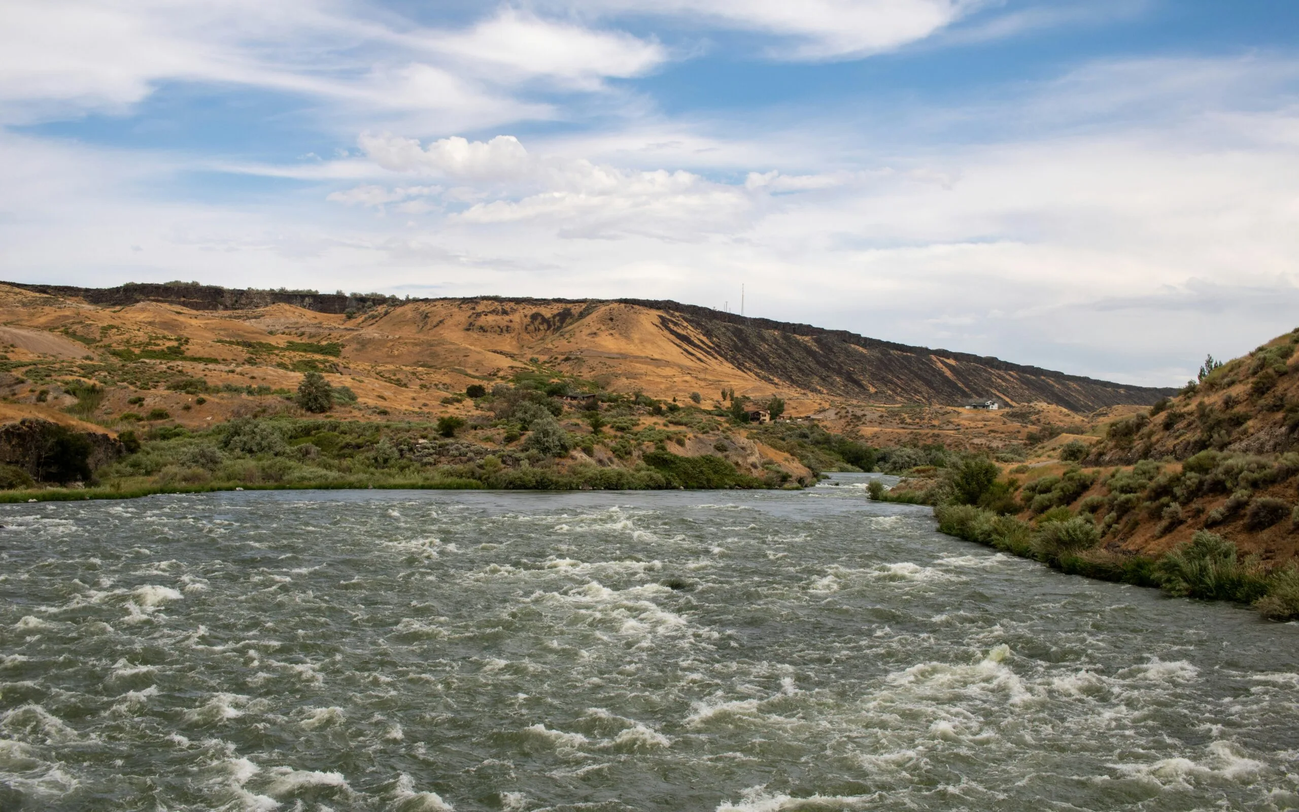A river running through a lush green hillside