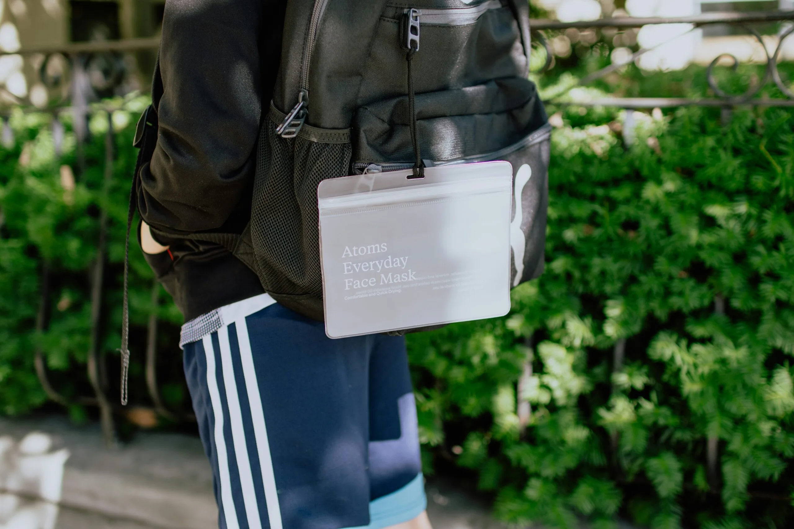 person in black jacket carrying white and black backpack